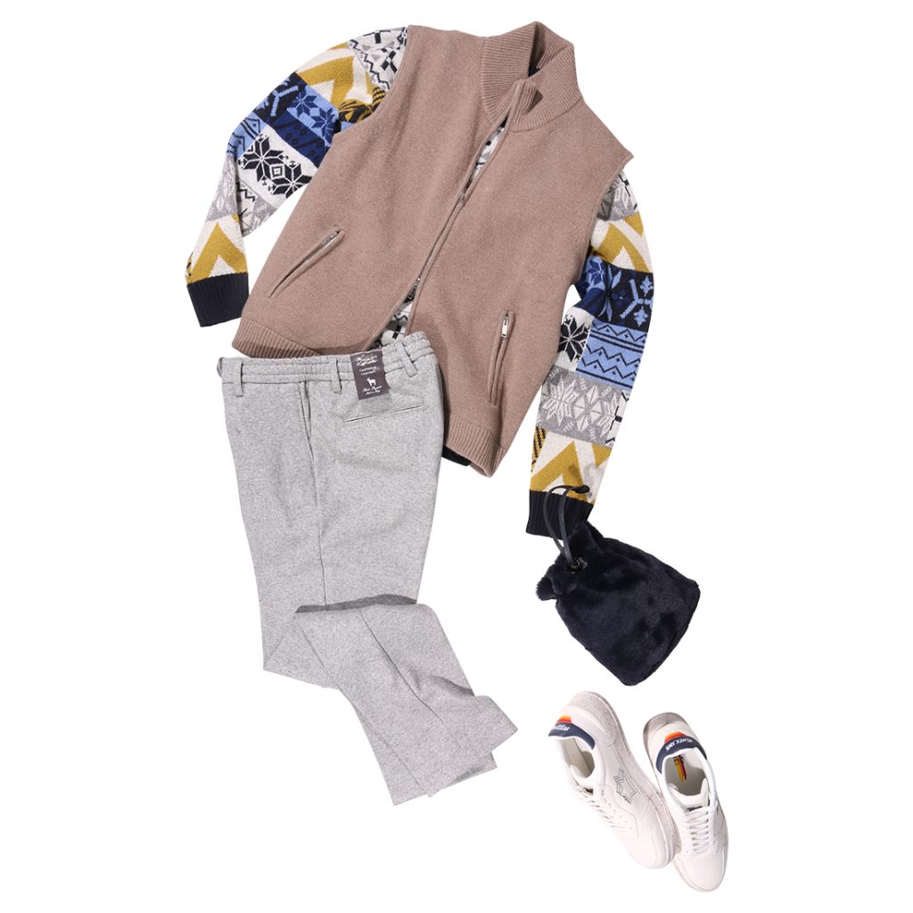ダニエレフィエゾーリのニットベストを主役に、幾何学柄ニットをレイヤードした大人のカジュアルコーディネート。グレーパンツと白スニーカーで軽快さを加えた上品なスタイル