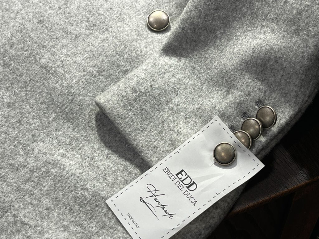 EREDI DEL DUCA グレー ウールコート 袖ボタンとブランドタグのディテール 上質素材を感じる仕立て