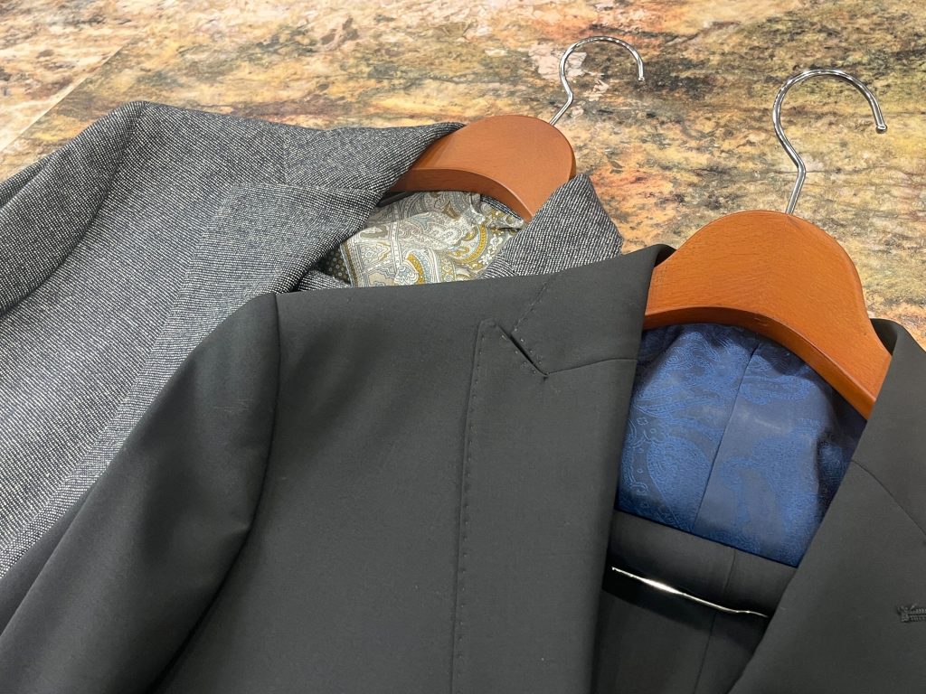 グレー、ブラックのETROが手掛けた2着のスーツ。どちらも知的な印象を与える佇まいです。