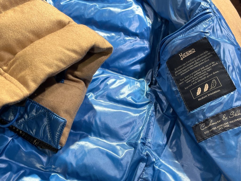 HERNO ダウンジャケットの鮮やかなブルー内装と品質タグ