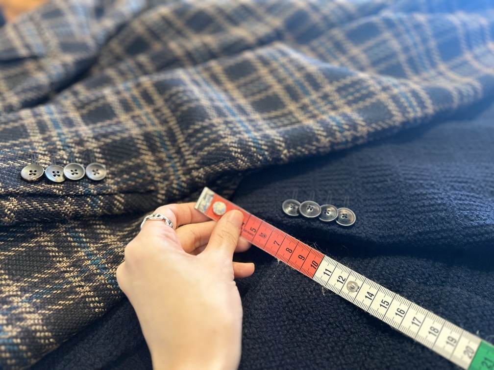 ジャケット袖口からボタン位置を実測している様子