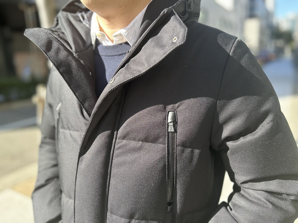 春の白い太陽光が黒ダウンに影を落とし、顔まわりが重たく見える状態を示した比較カット。