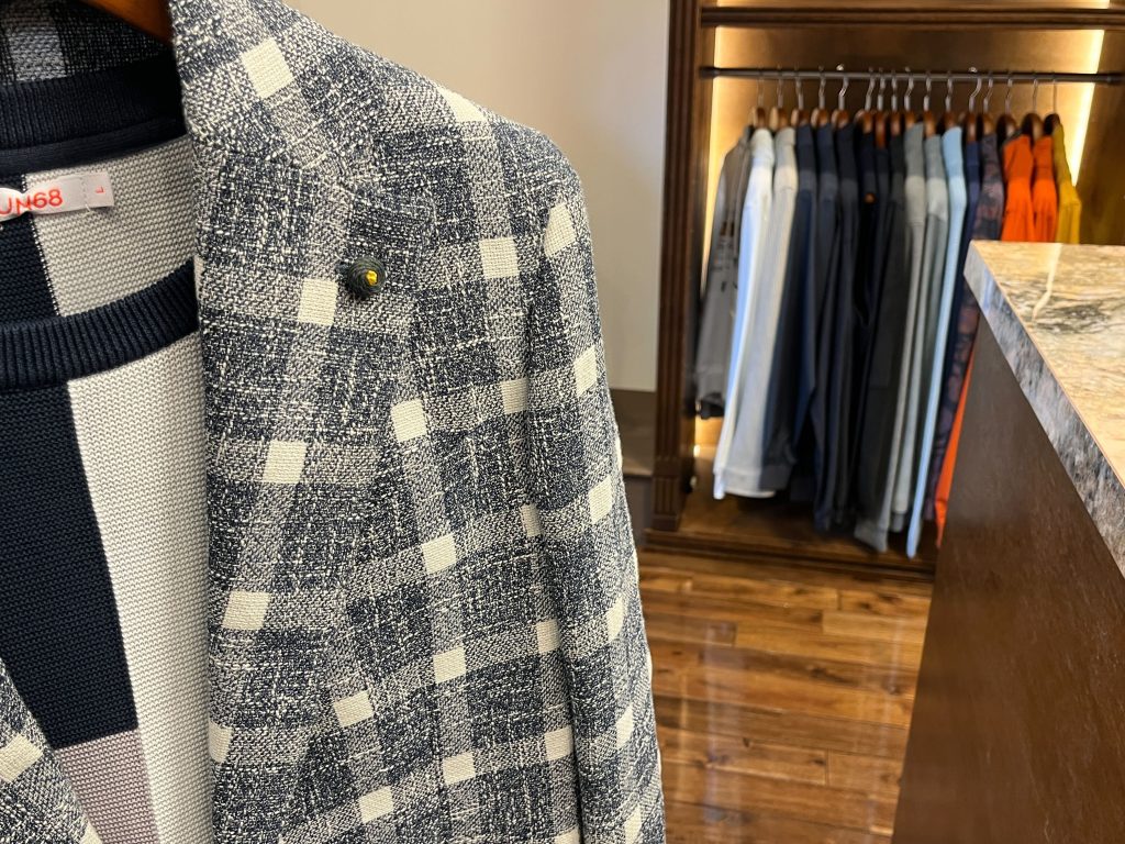 モノトーンチェック柄ジャケットのラペルディテールと店内ディスプレイの様子