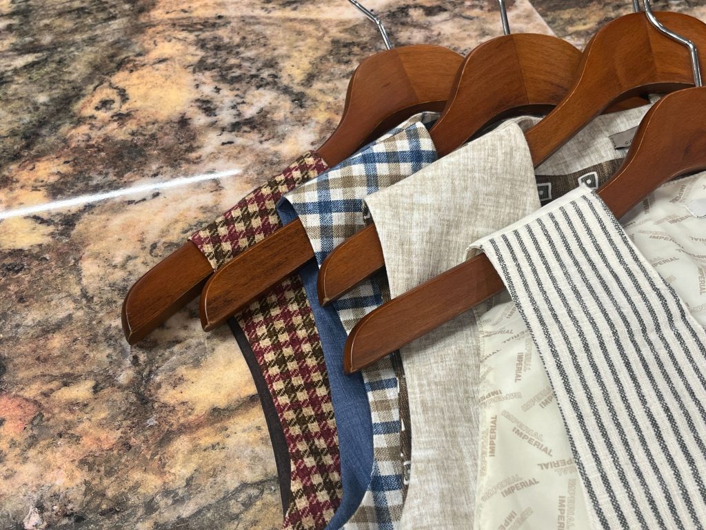 ジレ生地ディテール ハンガーに掛けたチェック柄やストライプの上質素材のバリエーション